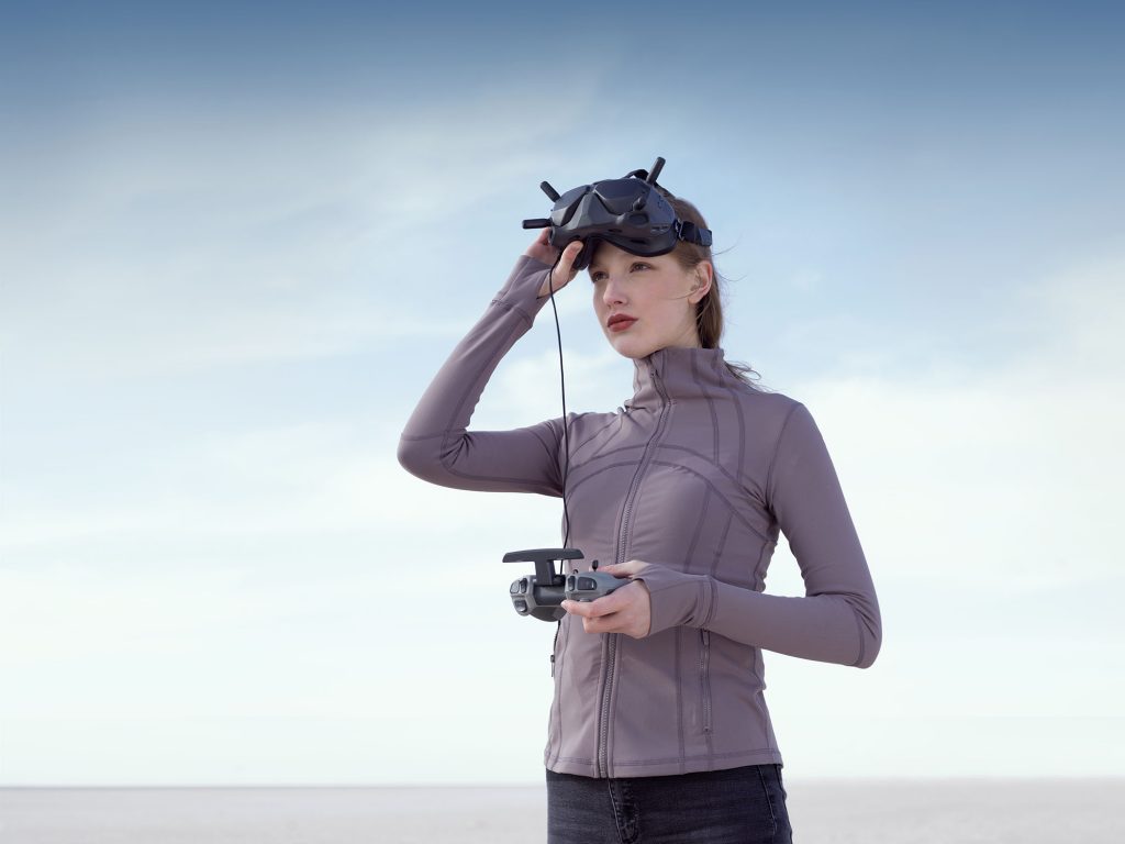Woman flying DJI Drone with goggles and controller
